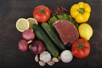 meat with vegetables on wooden background