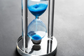 Time is passing. Blue hourglass close up