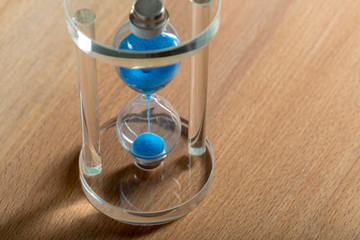 Time is passing. Blue hourglass close up