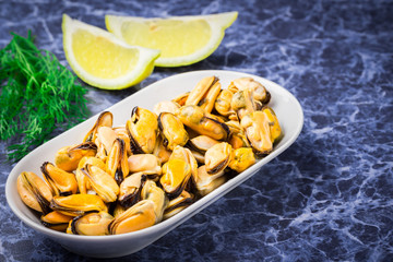 Delicious seafood in a plate on blue stone background.