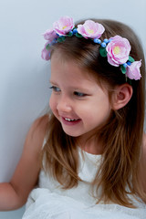 Charming girl with long ash-blond hair , lively blue eyes and a pinched nose, the bezel is handmade . Smiling, holding your hands up.Smiling and looking at camera