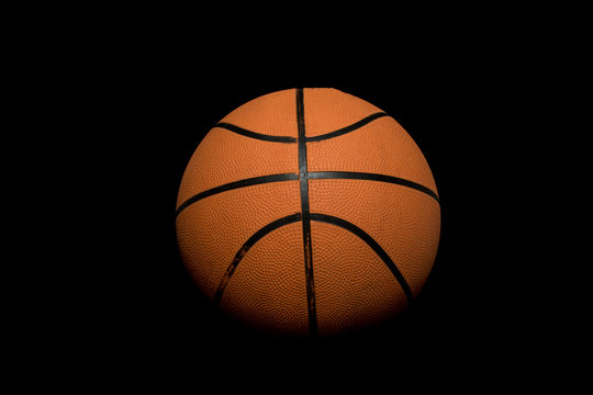 A single basketball isolated on a black background