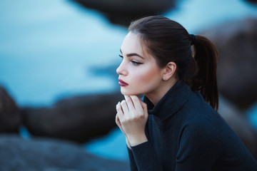 Naklejka premium Beautiful young woman. Dramatic outdoor portrait of sensual brunette female with long hair. Sad girl in depression.