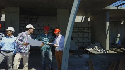 Aerial Shot Of Builders Team On Construction Site Discussing Plan Of Project With Architect And Contractor Using Blueprint On Digital Tablet - Powered by Adobe