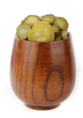 slices of pickled cucumber  in wooden cup isolated
