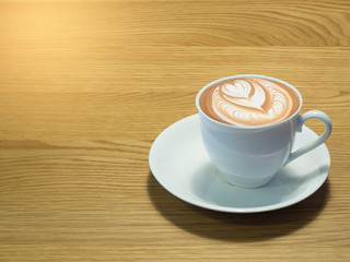 A cup of coffee and notebook on wood table . Coffee break in morning ,break working  / selective focus.Blank seating  indoor in living room .copy space for create idea for business.
