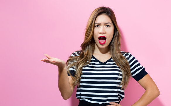 Unhappy young woman on a pink background