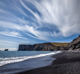 Black sand beach at Dyrholaei Iceland with an amazing Sky