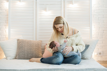 Obraz premium Pretty woman holding a newborn baby in her arms