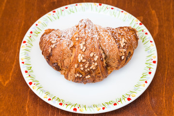 croissant filled by nuts and chocolate on table