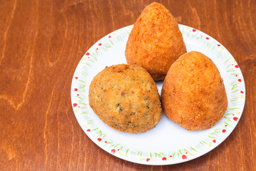 various rice balls arancini on plate on table