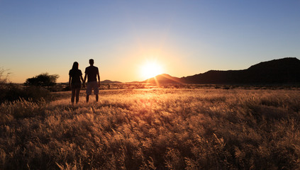 Couple at african savanna landscape. Namibia, South of Africa.