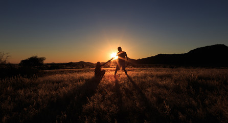 Fototapeta na wymiar Couple help teamwork and trust silhouette at african savanna landscape. Namibia, South of Africa.