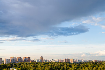 Obraz premium rainy gray cloud in blue evening sky over city
