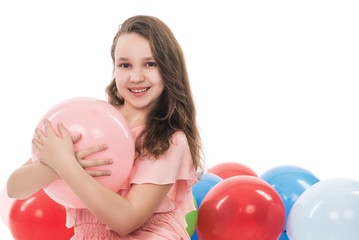 Naklejka premium happy smiling young woman or teenage girl in pink dress with colorful helium air balloons, holidays concept, isolated on white background