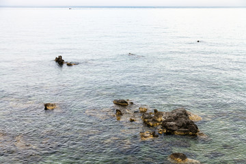 rocks in water near waterfront in Giardini Naxos