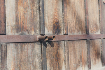 Natural wood doors with rusty metal handles, background.