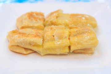Roti roll with banana inside and milk pouring on top 