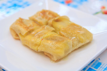 Roti roll with banana inside and milk pouring on top 
