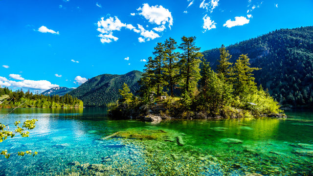 Small island in the middle of the crystal clear waters of Pavilion Lake in Marble Canyon Provincial Park, British Columbia. The lake has international fame because of freshwater microbialites