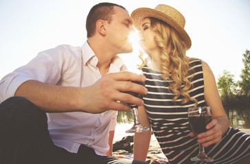 Happy couple. Low angle view of beautiful young woman and man keeping eyes closed and sitting close...
