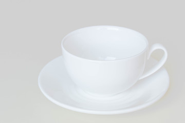 Obraz na płótnie Canvas White cup and saucer for tea or coffee isolated on a light background.
