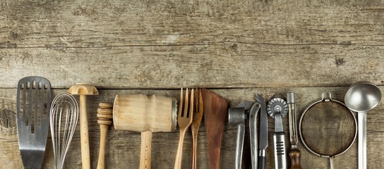 Kitchen tools on a wooden table. Cook's tools. Traditional equipment of rural cuisine. © martinfredy