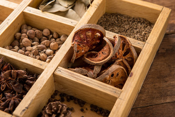 Assorted dried herbs in a printers tray with focus to chamomile flowers and a blend of mixed herbs for use in the kitchen to season and flavour food.