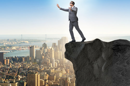 Blindfold Businessman Standing On Tip Of Cliff