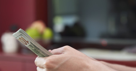 side shot of man counting three thousand dollars