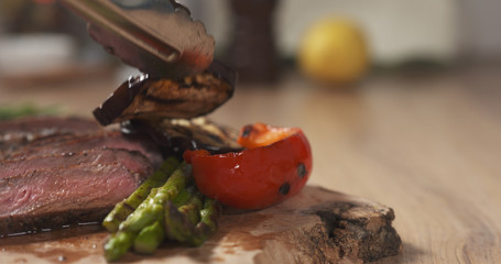 serving medium rib eye steak with grilled vegetables