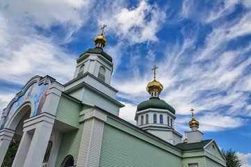 Christian temple and golden domes against the sky with clouds