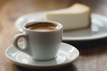 fresh espresso and cheesecake on table