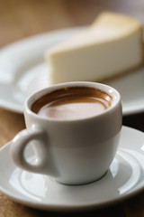 fresh espresso and cheesecake on table