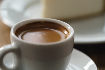 fresh espresso and cheesecake on table