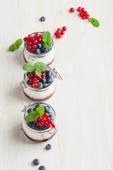 Italian dessert panna cotta with berry sauce in glass jars