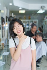 Young beautiful asian girl with stylish bob haircut, her smile and strike a handsome pose in the Barber shop.