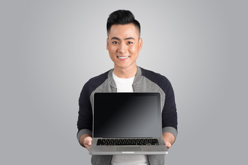 Confident young asian businessman showing laptop screen.