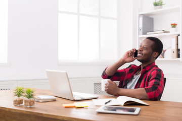 Naklejka premium Young black businessman call mobile phone in modern white office