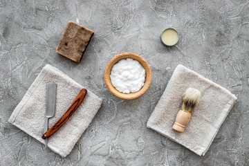 Fototapeta na wymiar Preparing for men shaving. Shaving brush, razor, foam on grey stone table background top view