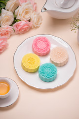 Sweet color of snow skin mooncake. Traditional mid autumn festival foods with tea on table setting.