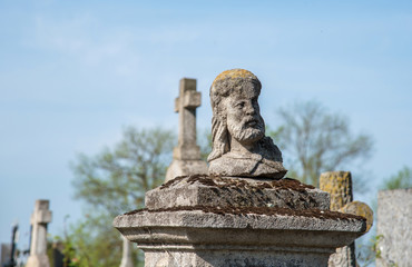 Obraz premium Head of the statue on the grave at the old cemetery