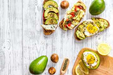 Vegetarian breakfast. Sandwiches with avocado, fried eggs and paprika on wooden table background top view copyspace