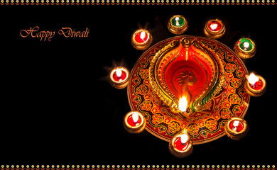 Diwali background content with decorations in diya and rangoli pattern.