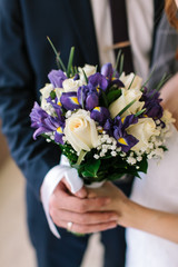 the groom in a blue suit gives to bride a wedding bouquet from fresh flowers. date, engagement, romantic, love, feeling, event concept. wedding ceremony.