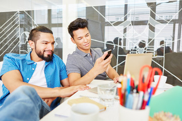 Zwei Gründer lesen SMS auf Smartphone