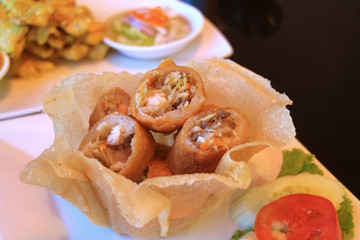 Deep fried spring rolls in a crispy eatable bowl served with fresh sliced vegetable 