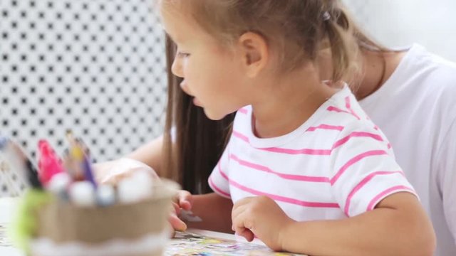 Mother and daughter doing a puzzle together in the light living room