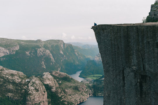 Man sitting on the edge of Preykestalen, Norway