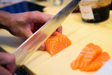 sushi chef cutting salmon